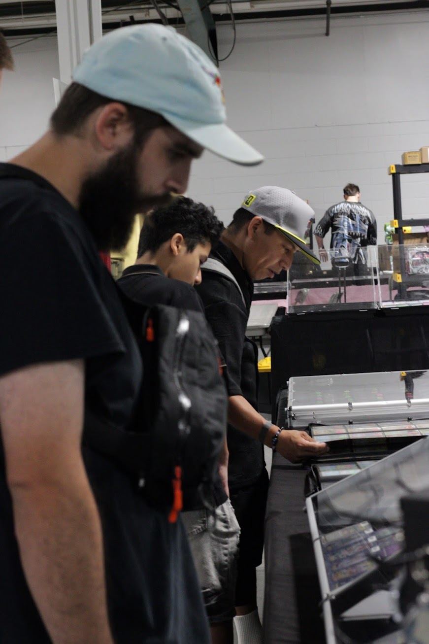 Attendees leaning over a glass case of graded cards