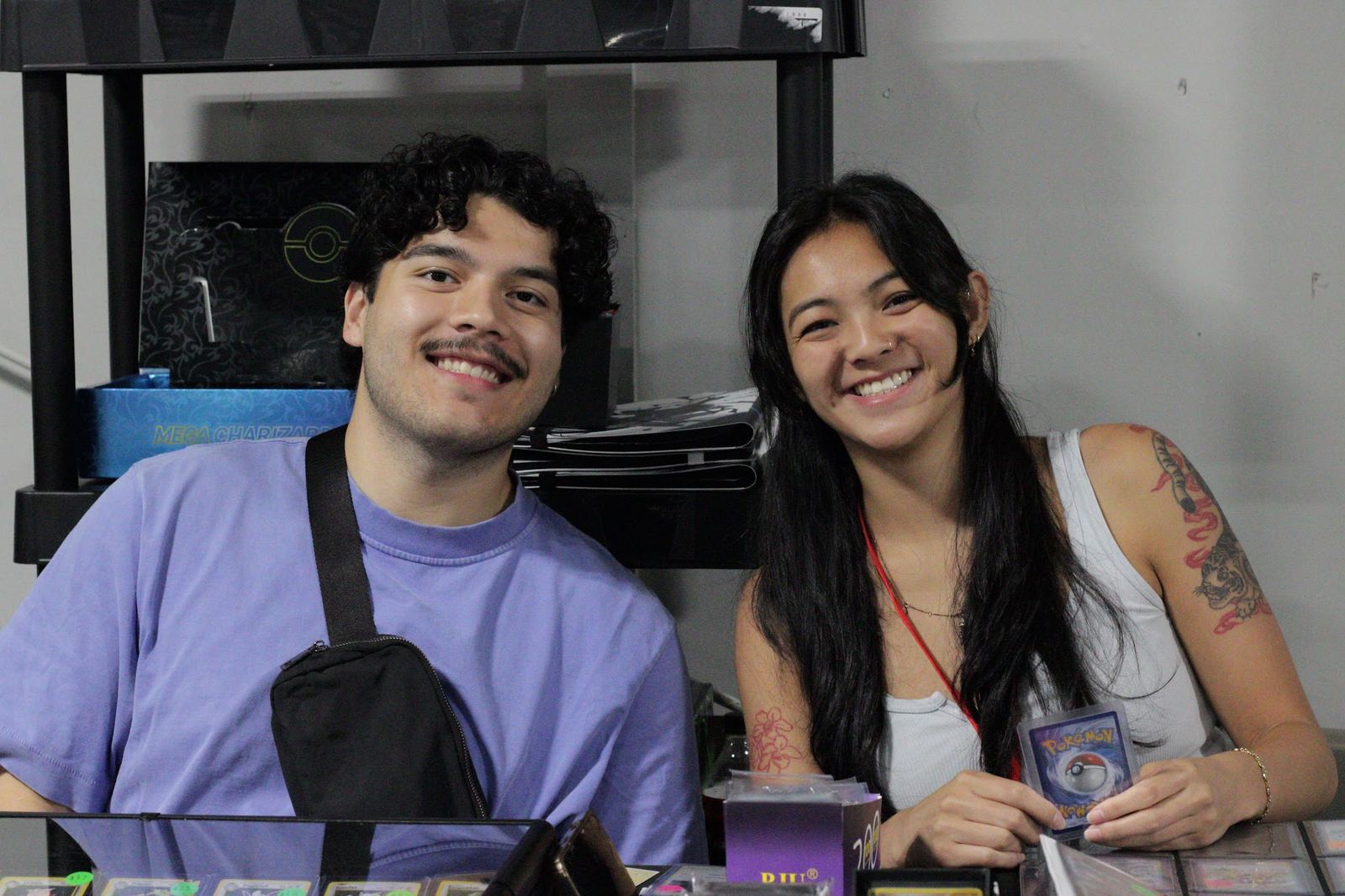 A couple showing off cards at their vendor table
