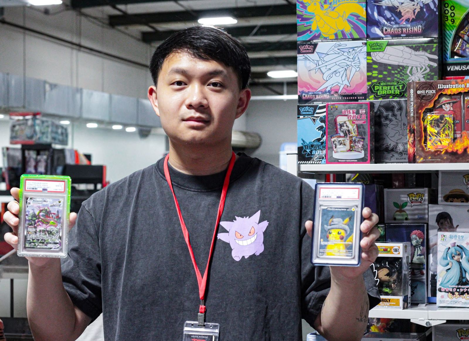 A collector holding up two graded cards